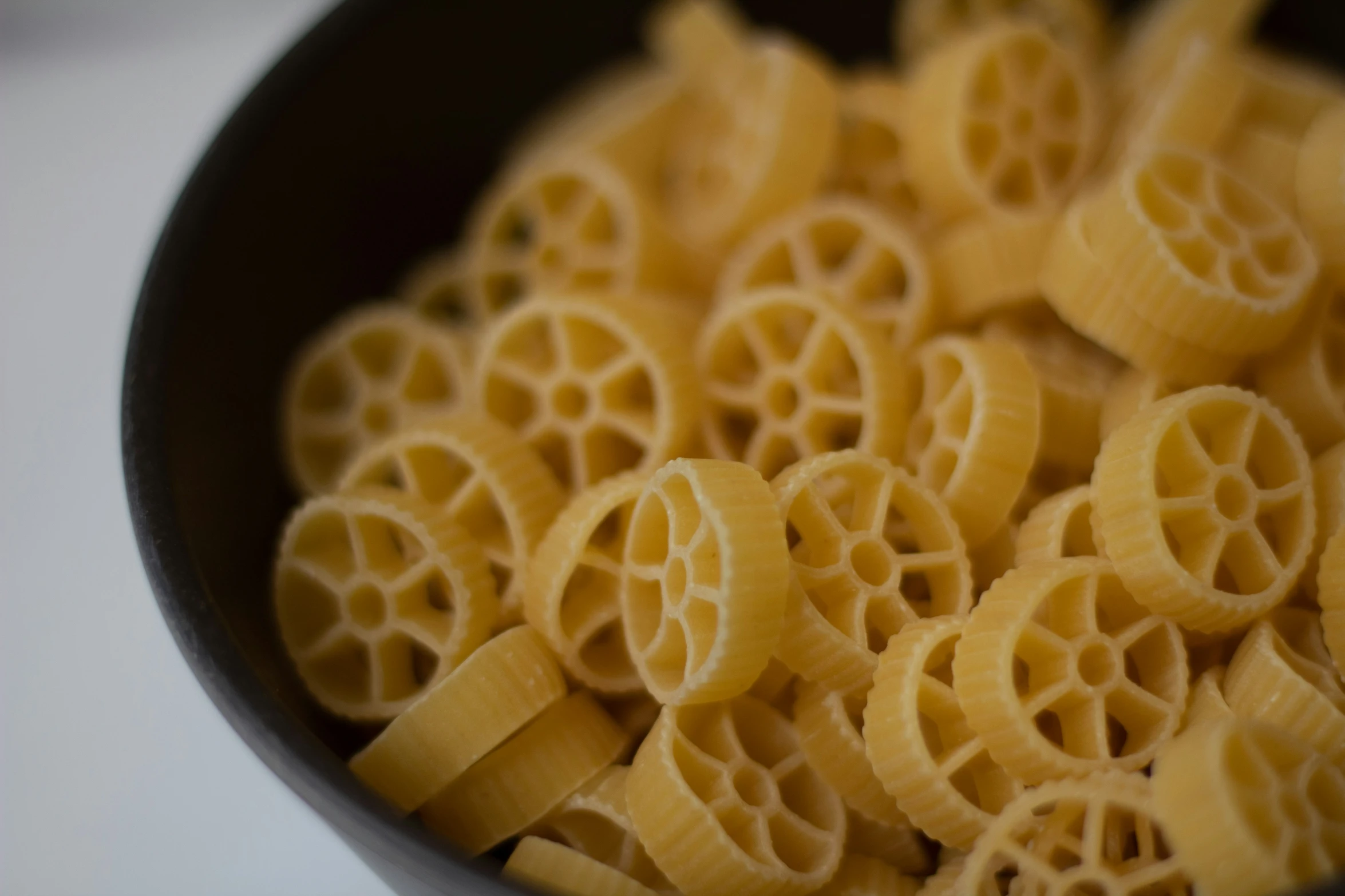 macaroni shells in a black bowl filled with sauce