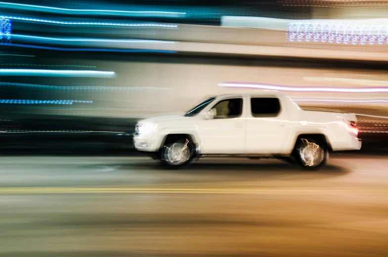 a white truck driving down a street next to a building