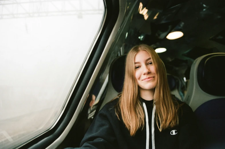 young woman smiling while driving on a train