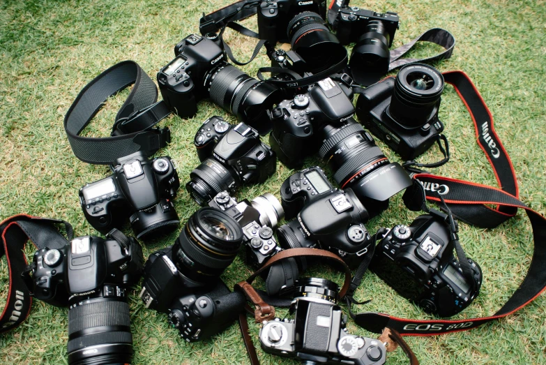 many different cameras laying on the ground next to each other