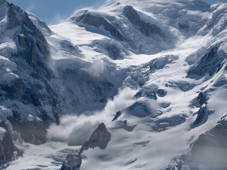 the view from a very large mountain looking down at a snow covered ridge