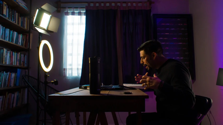 a man sits at a desk looking down