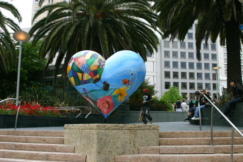 a giant heart shaped balloon sitting on the side of steps