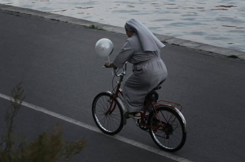 a woman riding her bicycle along the beach