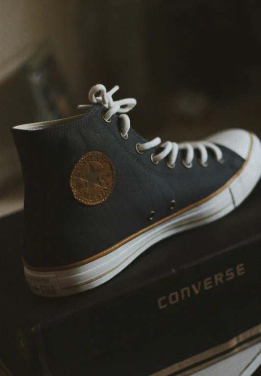 the converse shoes are on top of books