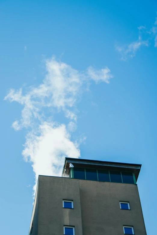 a very tall building under a blue sky with clouds