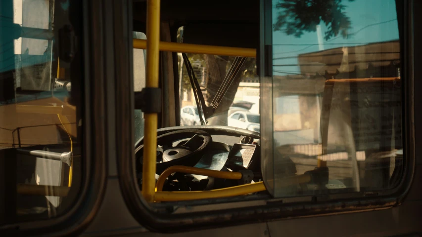 the interior view from a city bus looking out at a parking lot