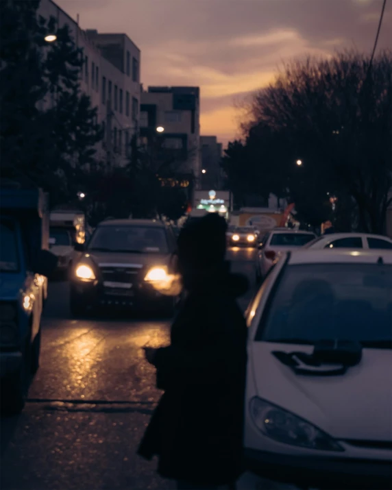 the silhouette of two people is seen walking in front of the street traffic