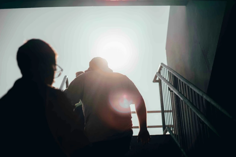 a couple walking down some stairs with their shadows on them