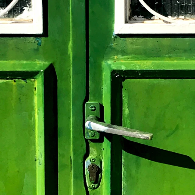 a close up of a green door and the handle