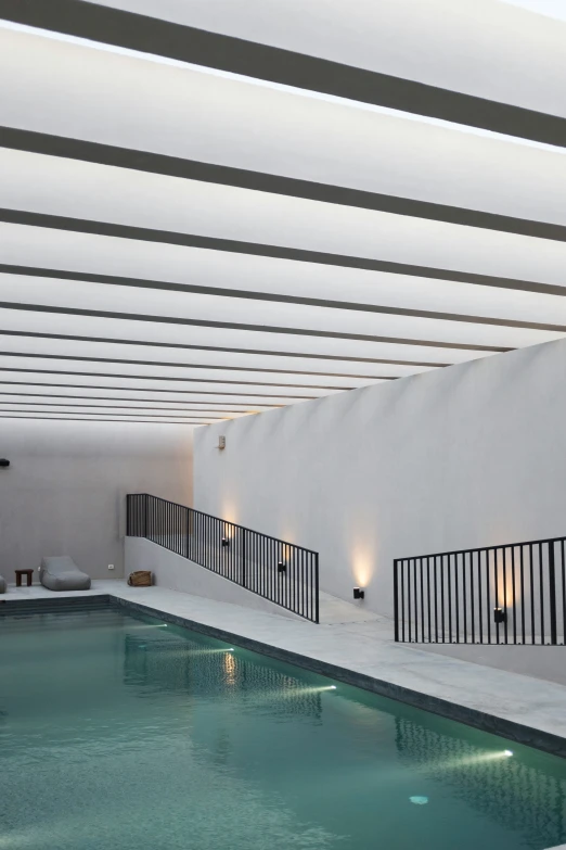 an empty pool with lots of windows, lights and lights hanging from it
