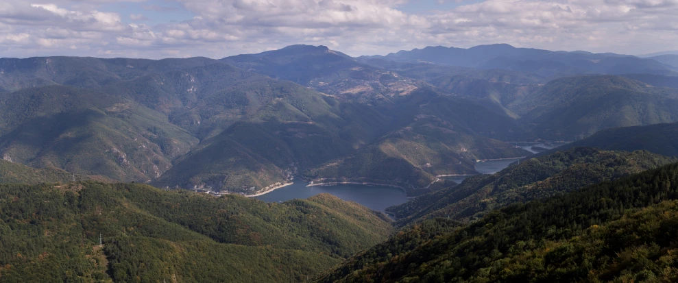 the view from the top of a mountain of water and green mountains