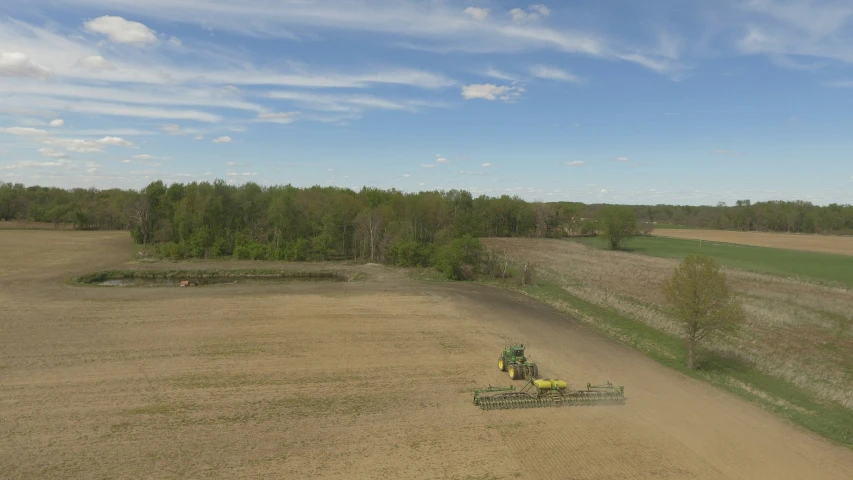 a farm field with a tractor and a plow