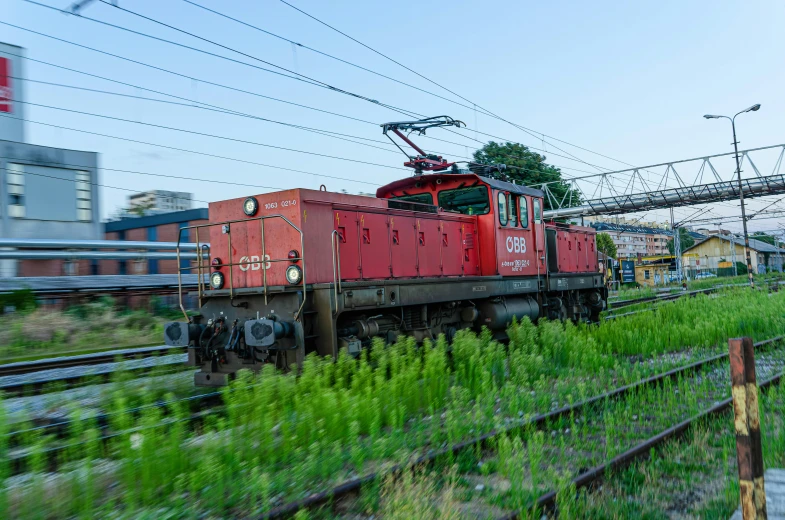 a train moving along the track near a tall building