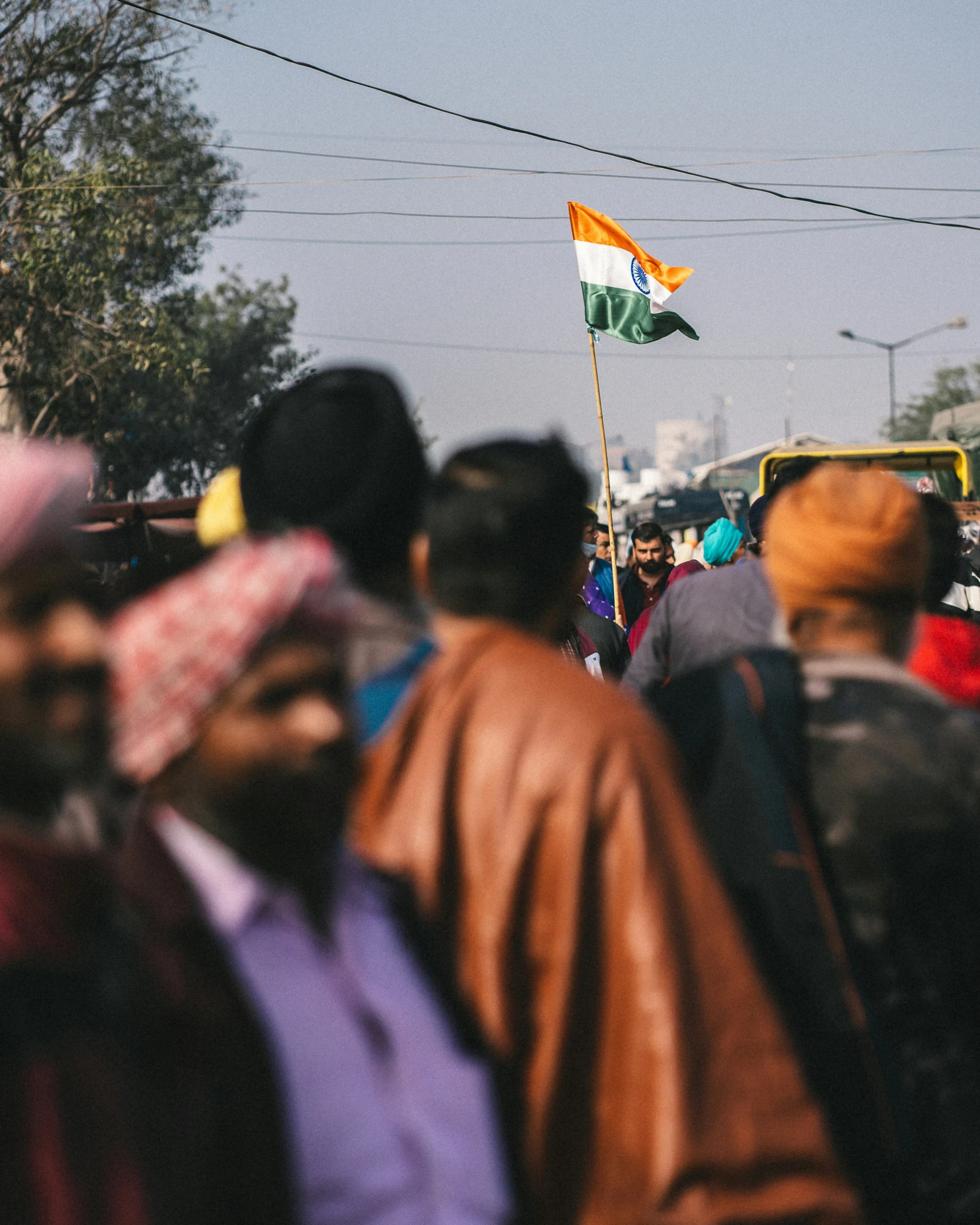 the large crowd of people are marching with flags