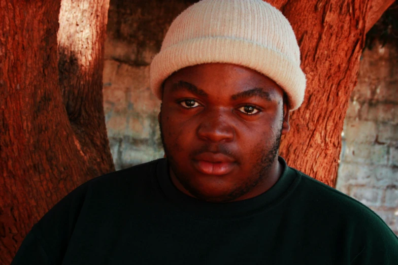 a man wearing a hat stares at the camera