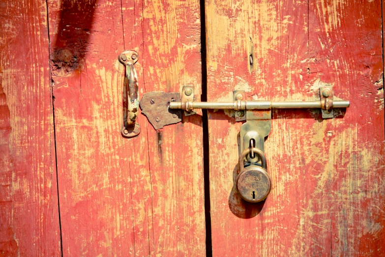 an old metal latched on red wooden door