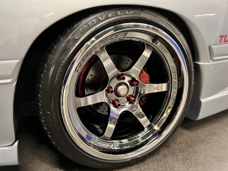 some metallic and black rims are on the tire of a silver car