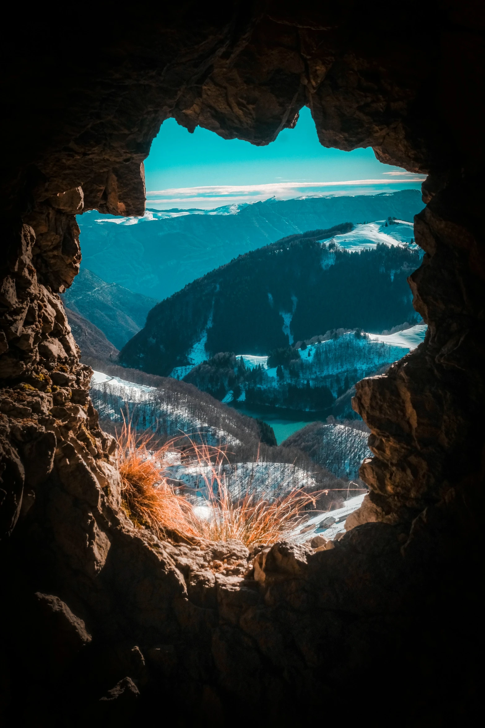 looking out from the top of a mountain, towards mountains and a body of water