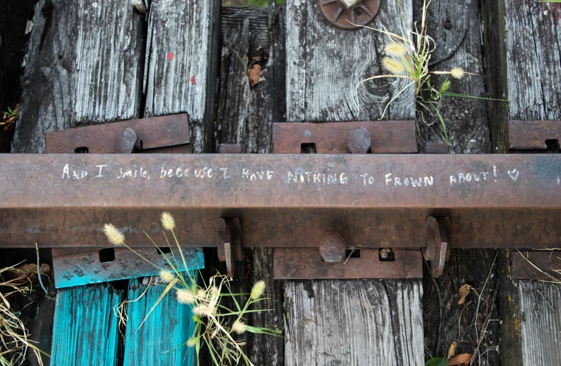 an old iron and rusty railroad track that has written on it