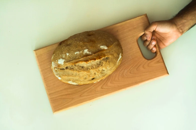 a piece of bread on top of a wooden  board