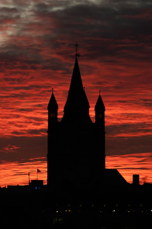 the sunset behind an old building with three steeples