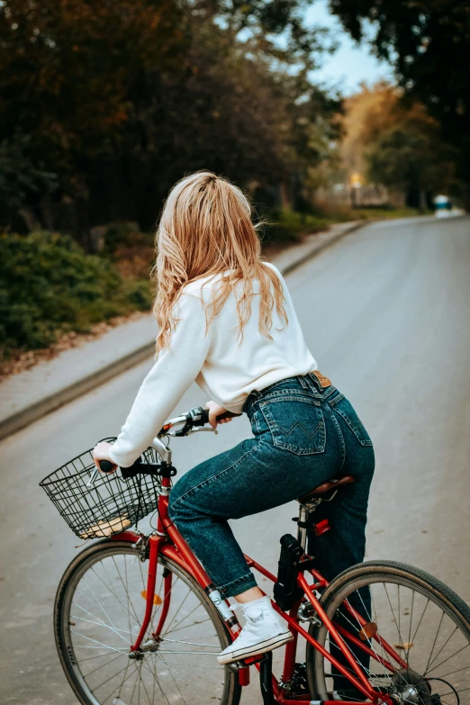 woman riding red bike on a paved road