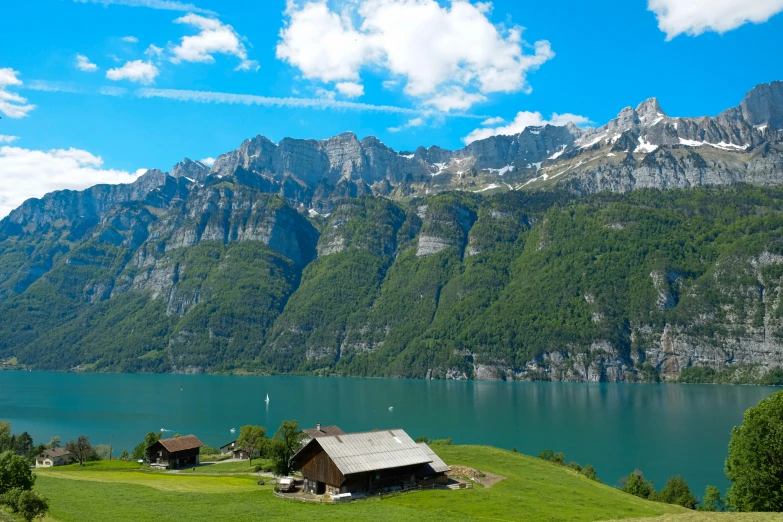 a lake surrounded by mountains near a cabin