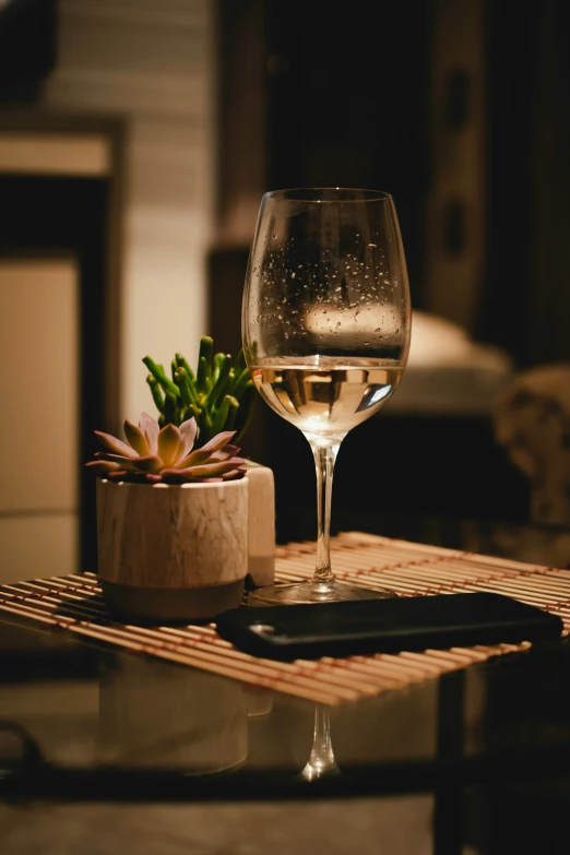 a glass of white wine sitting on a table