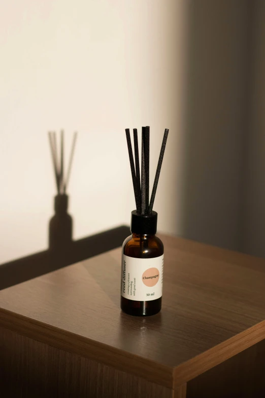 a bottle of diffuser with some sticks in it on a wooden table