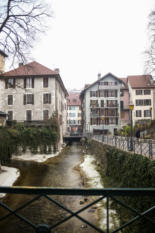 a river running under buildings next to tall buildings