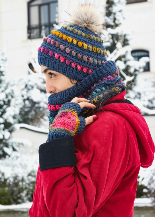 the woman is wearing the hat and scarf while holding the hand on her shoulder