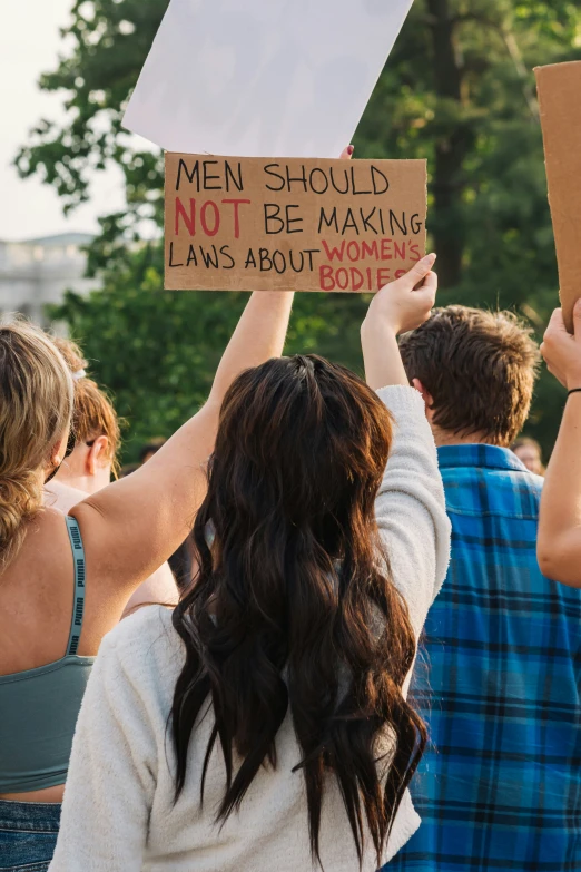 a woman holding a sign at a demonstration