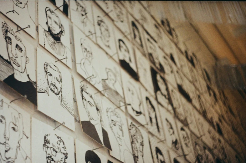 several face drawings are shown on the wall