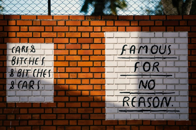 several signs are painted on the brick wall