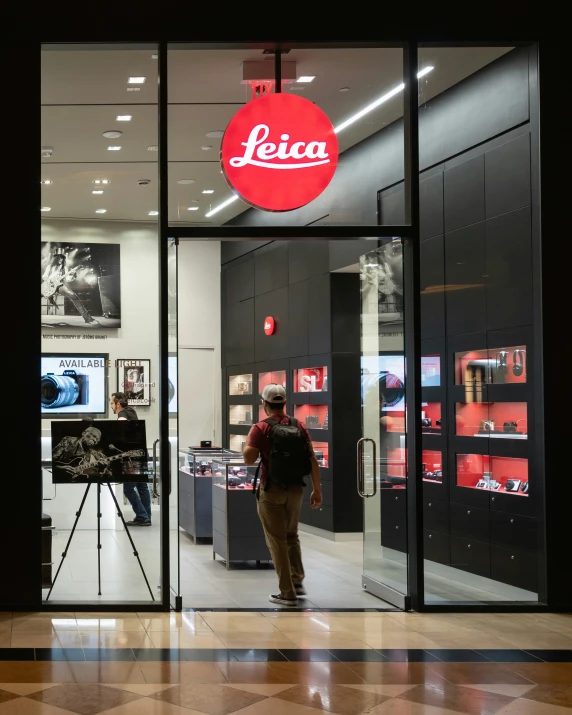 a man standing in a store doorway next to a camera