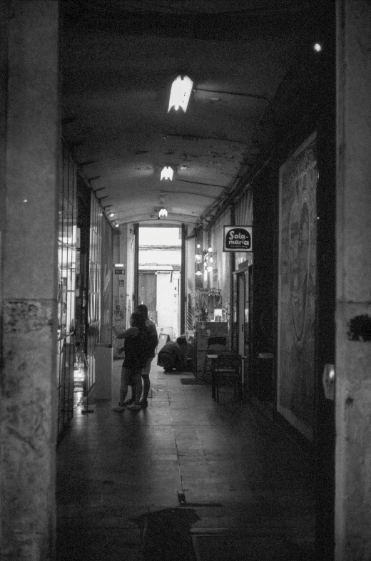 a couple of people walking down a hallway next to each other