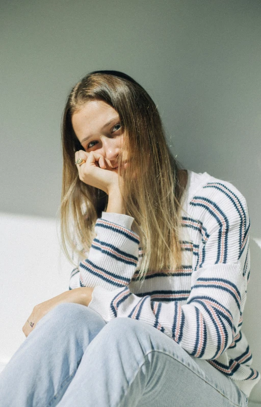 a girl is sitting on the floor while looking at soing