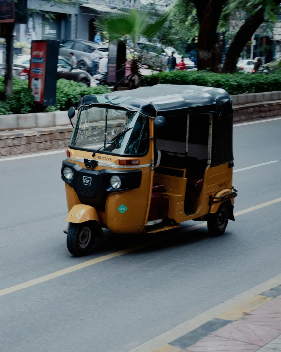 an orange and black three wheeled vehicle on a street