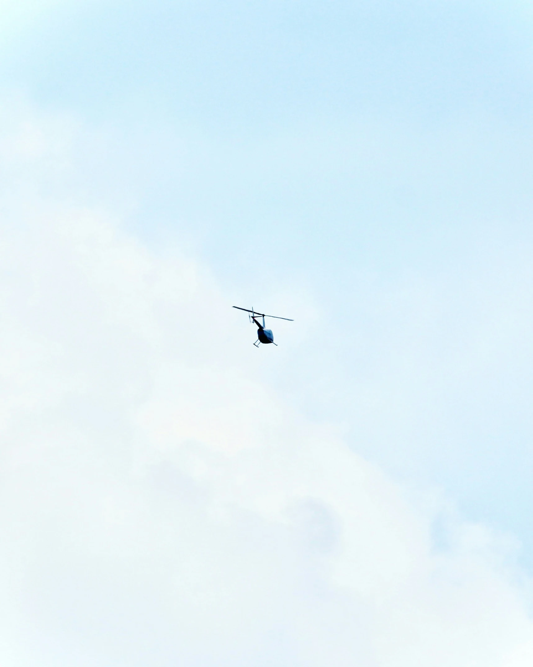 an air plane flying on a cloudy blue sky