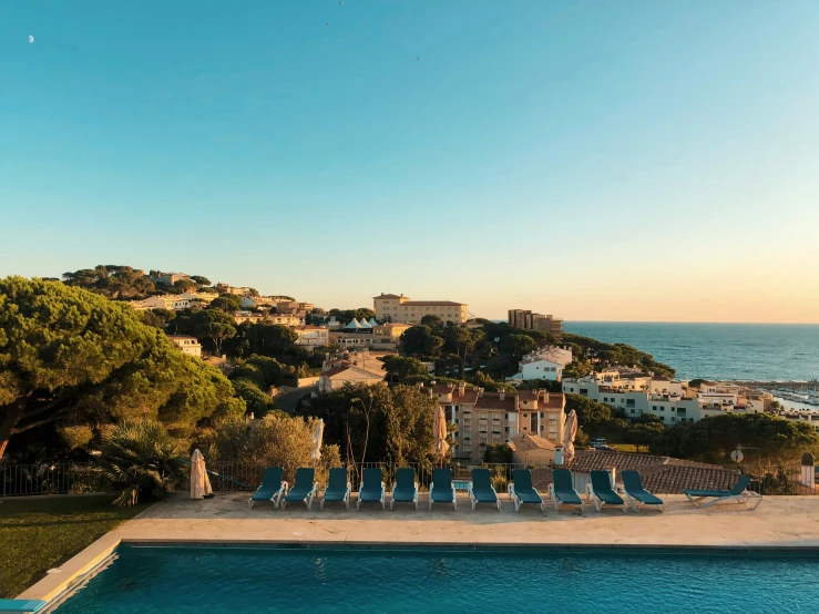 several lounge chairs are sitting on a cliff over an empty pool