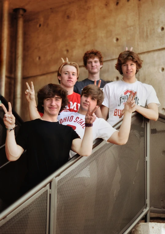 seven boys in black and white shirts standing on some steps