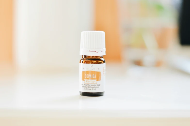 an essential oil bottle sitting on a white table