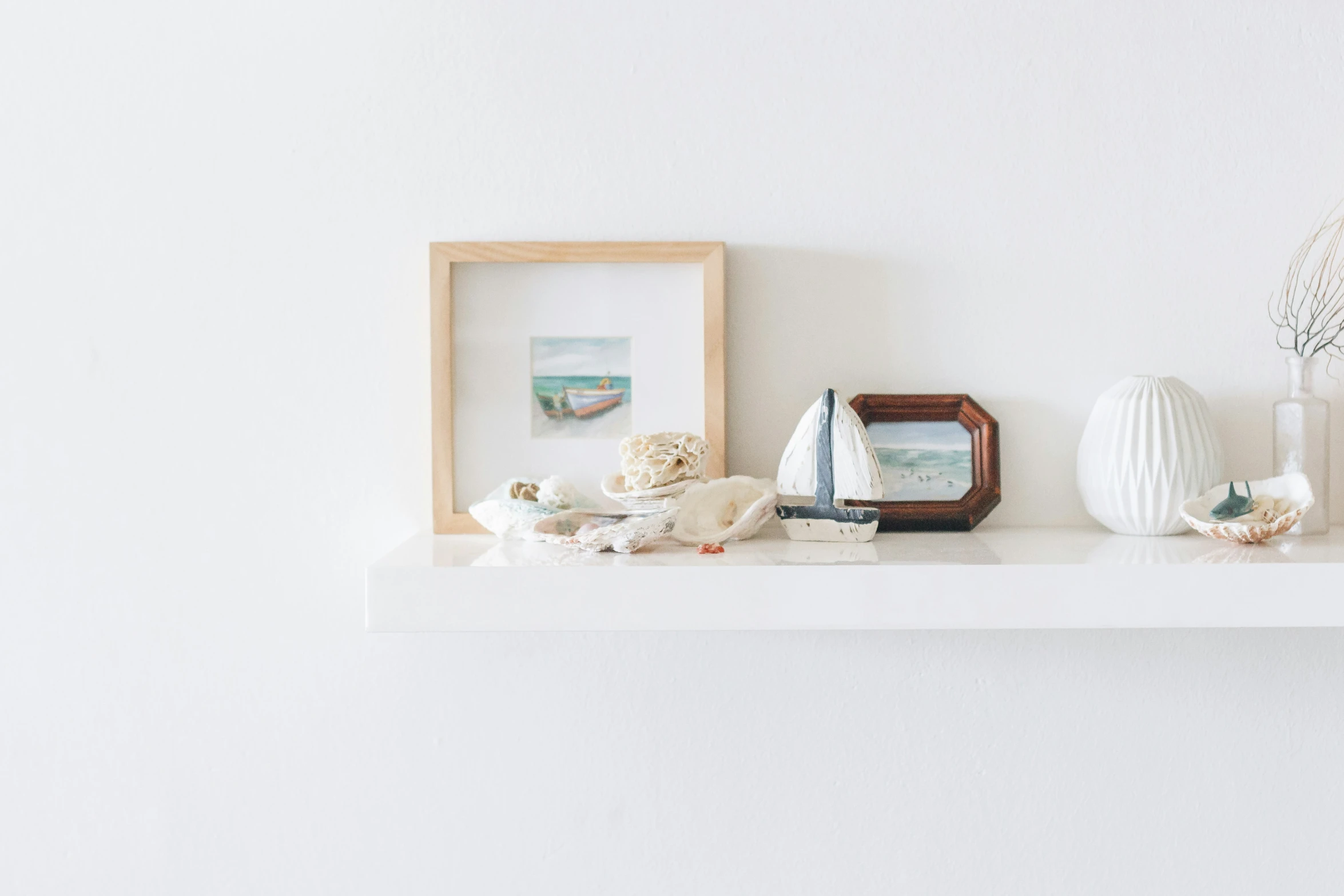 a white shelf with vases, a po and a picture frame