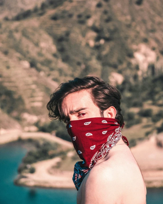 a man wearing bandana is looking away from the camera