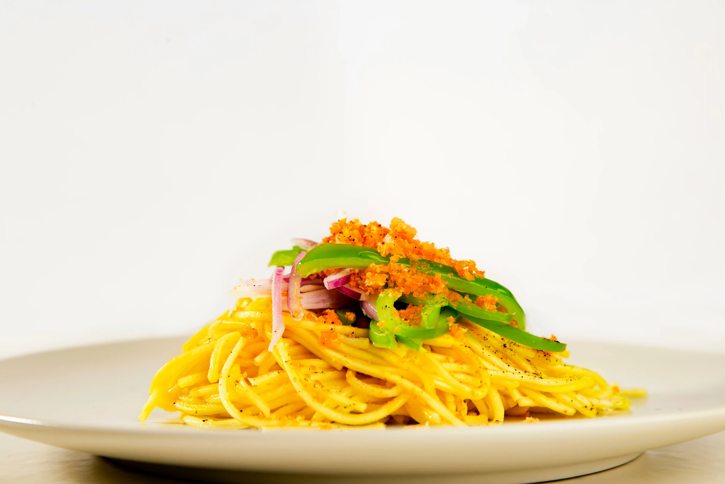 a white plate of noodles covered in sauteed cheese