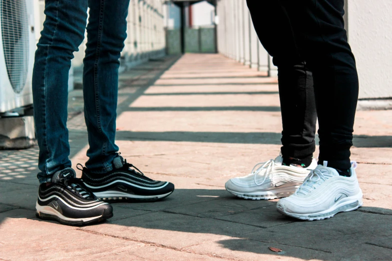 the legs of two people wearing white sneakers standing next to each other
