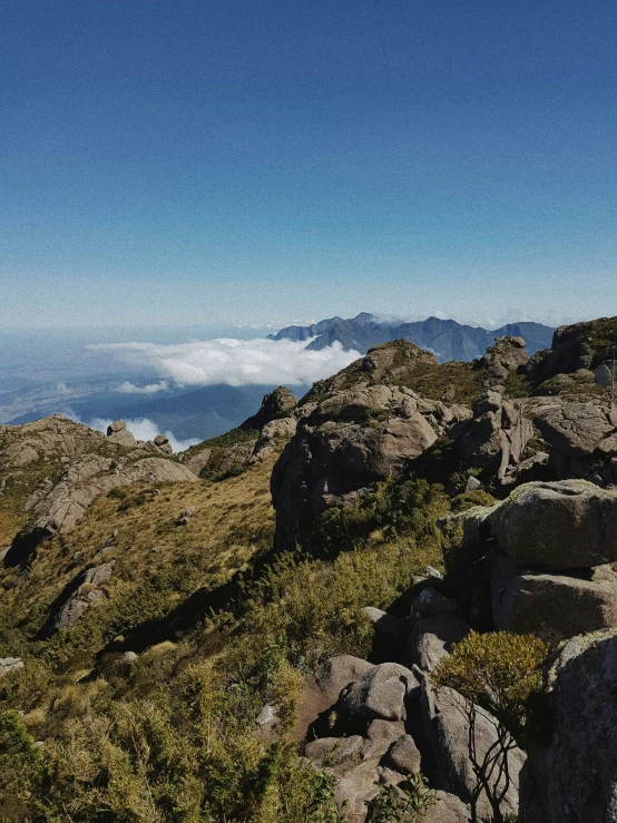 a person hiking uphill overlooking the clouds and mountains