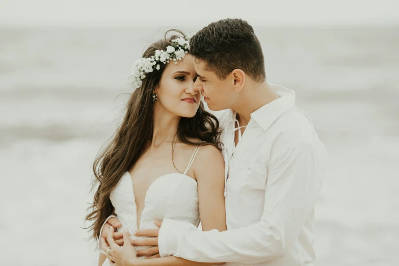 an image of a bride and groom kissing on the beach