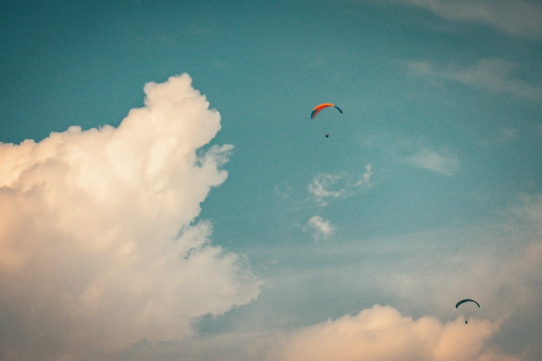 a couple of kites flying in the sky with clouds